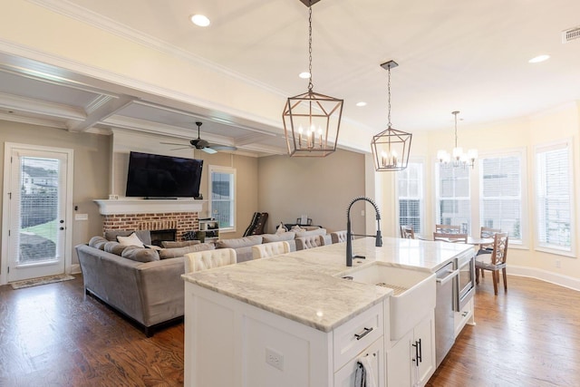 719 Nuttall St, Evans, GA 30809 - kitchen featuring a ceiling fan, dark wood-type flooring, light stone counters, hanging light fixtures, and crown molding