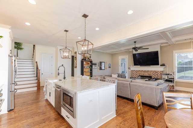 719 Nuttall St, Evans, GA 30809 - kitchen with white cabinets, appliances with stainless steel finishes, ceiling fan, light stone countertops, and light wood finished floors