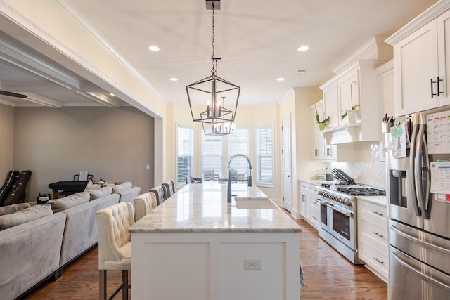 719 Nuttall St, Evans, GA 30809 - kitchen featuring appliances with stainless steel finishes, a breakfast bar area, a chandelier, a kitchen island with sink, and white cabinets