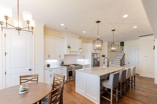 719 Nuttall St, Evans, GA 30809 - kitchen with appliances with stainless steel finishes, a chandelier, ornamental molding, white cabinets, and wood finished floors