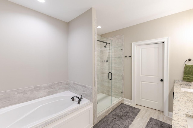 719 Nuttall St, Evans, GA 30809 - bathroom featuring a bath, a stall shower, vanity, recessed lighting, and wood finished floors