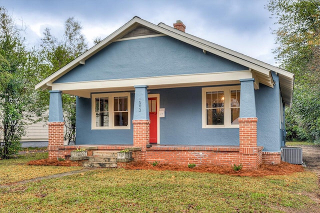 view of front of property featuring a porch, central air condition unit, and a front yard