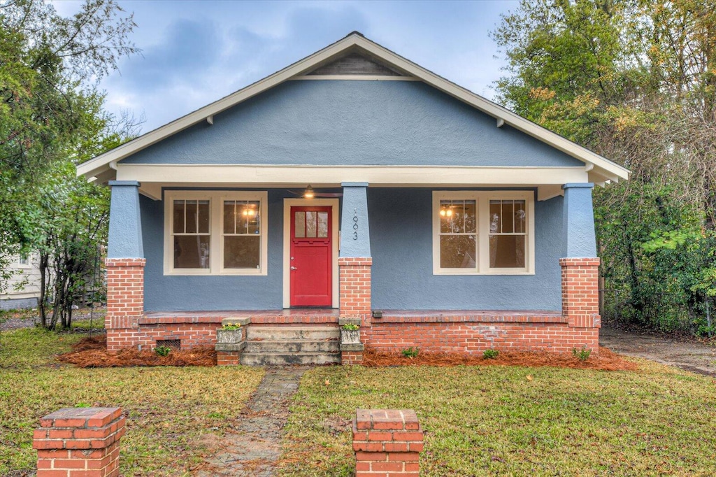 bungalow-style home with a front lawn