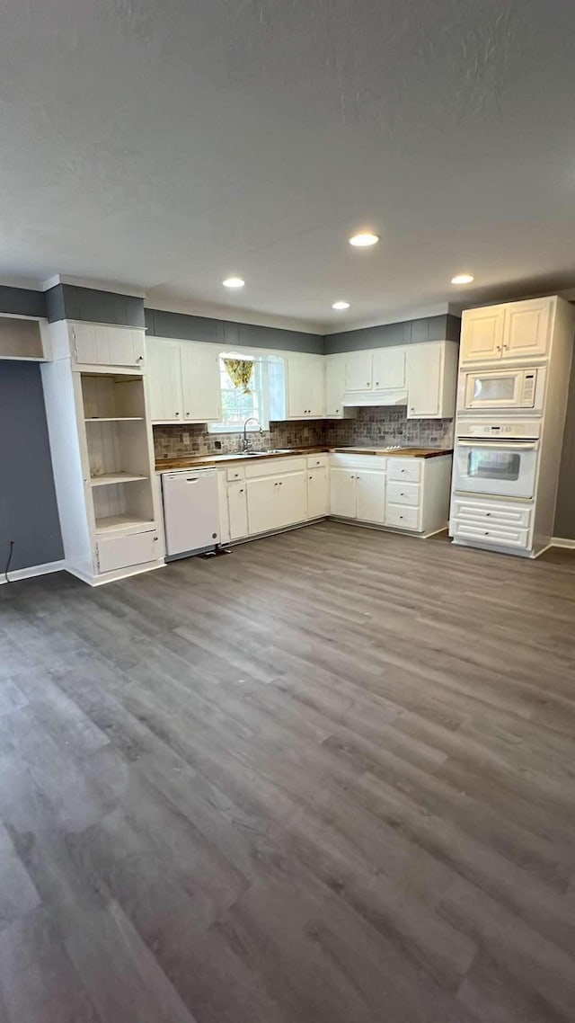 kitchen featuring white cabinets, sink, white appliances, and dark wood-type flooring