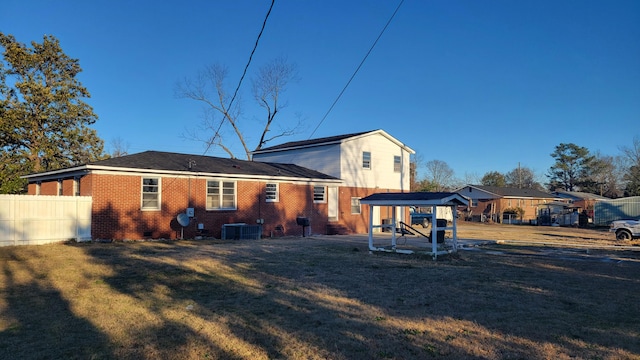 back of property with a lawn and central AC unit