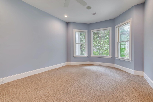 unfurnished room with ceiling fan, carpet floors, and a wealth of natural light