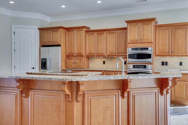 kitchen featuring backsplash, a kitchen island with sink, crown molding, and appliances with stainless steel finishes