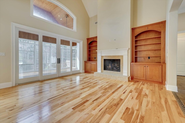 unfurnished living room with built in shelves, french doors, and plenty of natural light