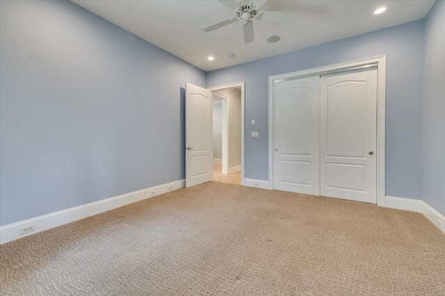 unfurnished bedroom with carpet, a closet, and ceiling fan