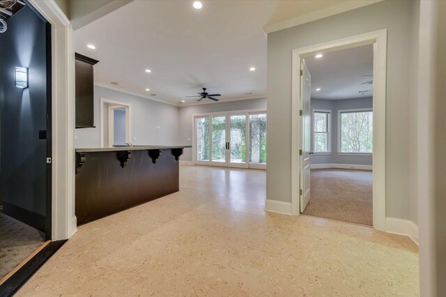 interior space featuring crown molding, french doors, ceiling fan, and a healthy amount of sunlight