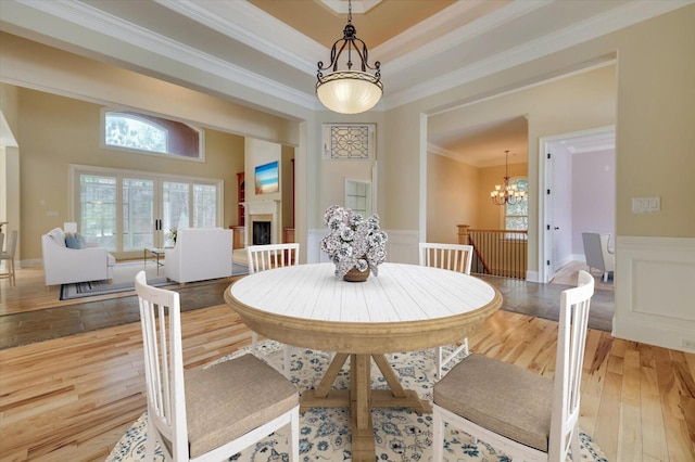 dining room with wood-type flooring, a notable chandelier, and ornamental molding