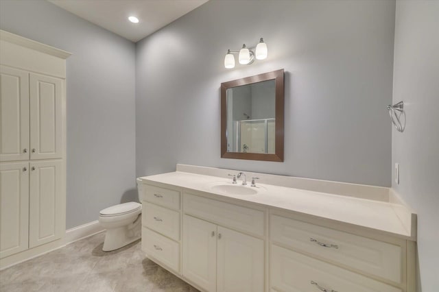 bathroom featuring vanity, a shower with shower door, and toilet