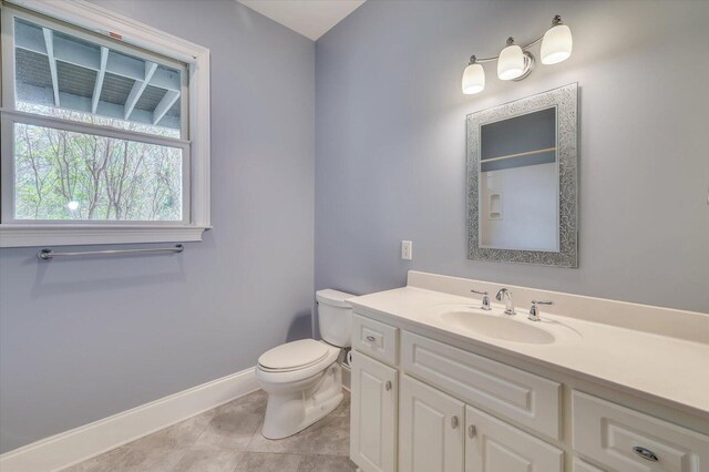 bathroom with tile patterned flooring, vanity, and toilet