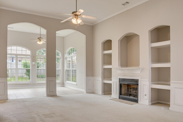 215 Mineral Ct, Evans, GA 30809 - unfurnished living room featuring a ceiling fan, carpet floors, built in shelves, a fireplace with flush hearth, and crown molding