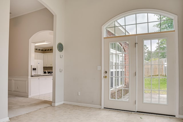 215 Mineral Ct, Evans, GA 30809 - doorway to outside featuring arched walkways, light tile patterned floors, light carpet, and crown molding