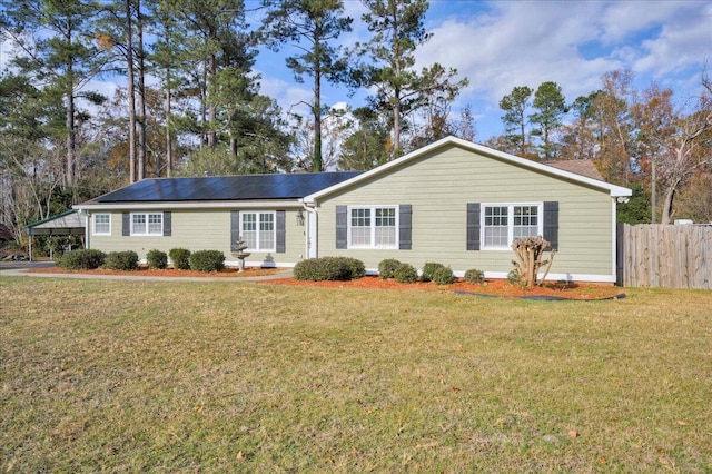 ranch-style home with solar panels and a front lawn