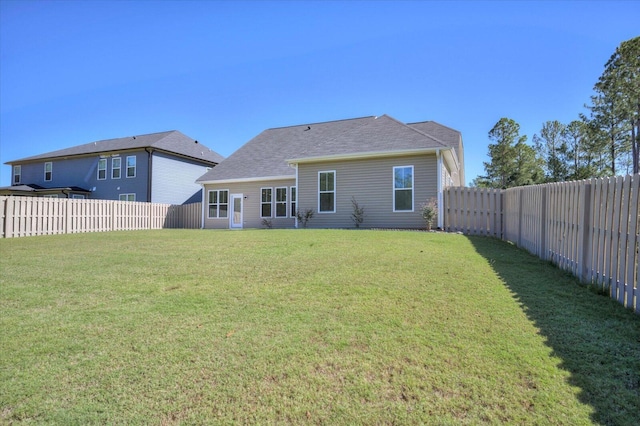 rear view of house featuring a lawn