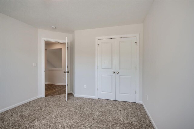 unfurnished bedroom featuring carpet flooring and a closet