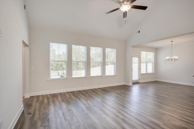 unfurnished living room featuring ceiling fan with notable chandelier, wood-type flooring, and high vaulted ceiling