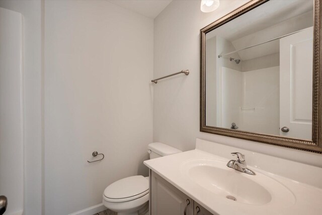 bathroom with a shower, vanity, and toilet