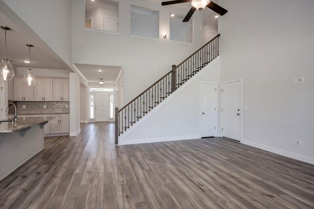 entryway with dark hardwood / wood-style floors, ceiling fan, a towering ceiling, and sink