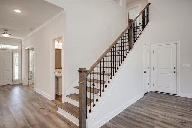 entryway with hardwood / wood-style flooring and crown molding