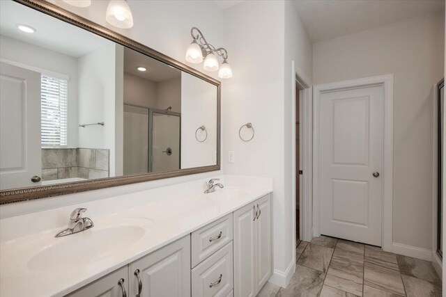 bathroom with vanity and a shower with door