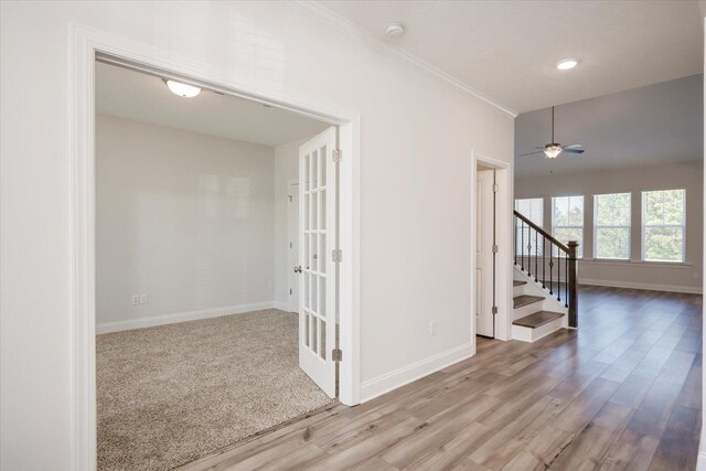 empty room featuring ceiling fan, light hardwood / wood-style flooring, french doors, and ornamental molding