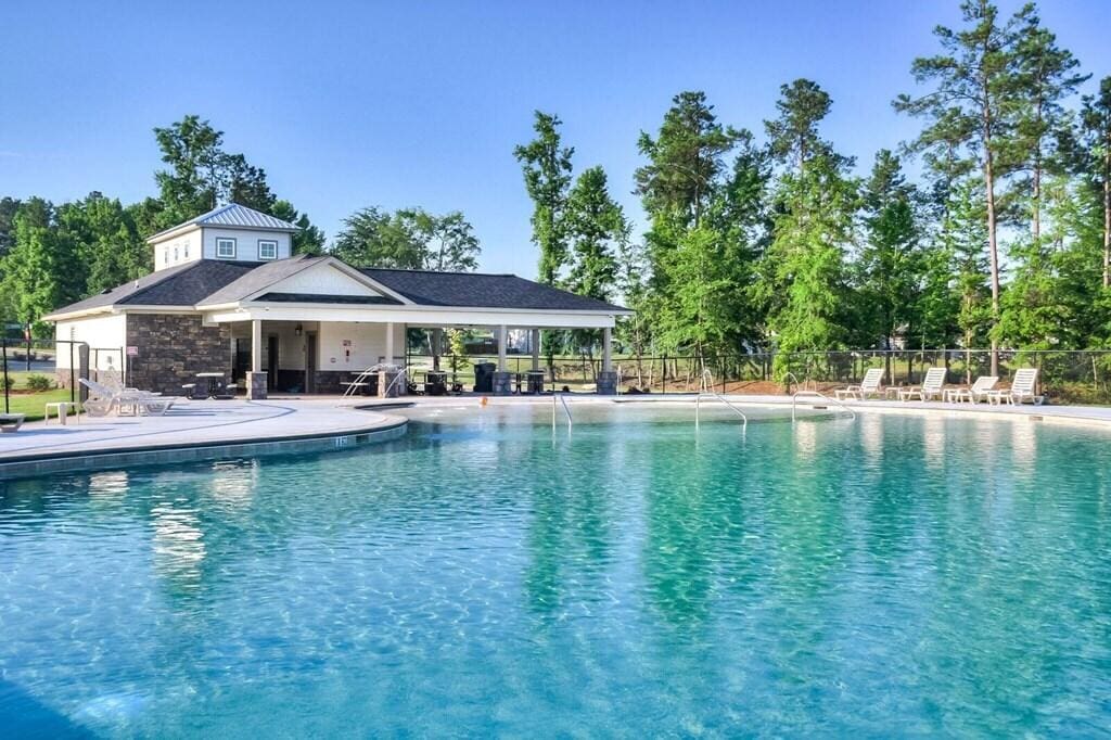 pool with a patio and fence