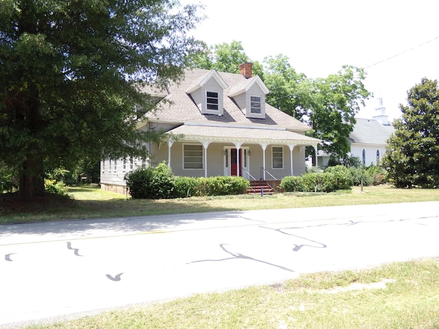 new england style home with a front lawn and covered porch