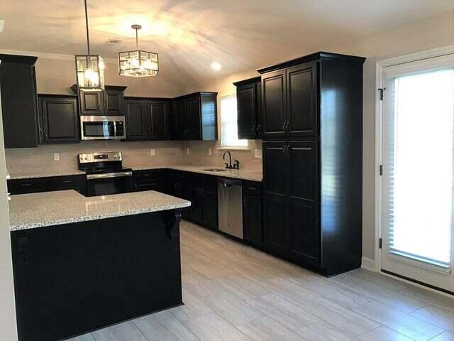 5186 Copse Dr, Augusta, GA 30909 - kitchen with stainless steel appliances, dark cabinets, tasteful backsplash, decorative light fixtures, and light stone countertops