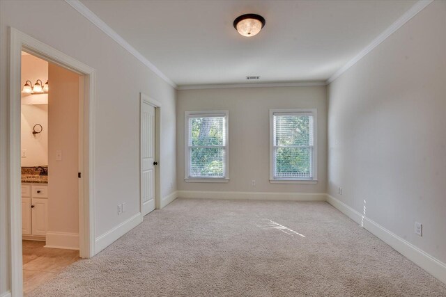 spare room with light colored carpet and crown molding