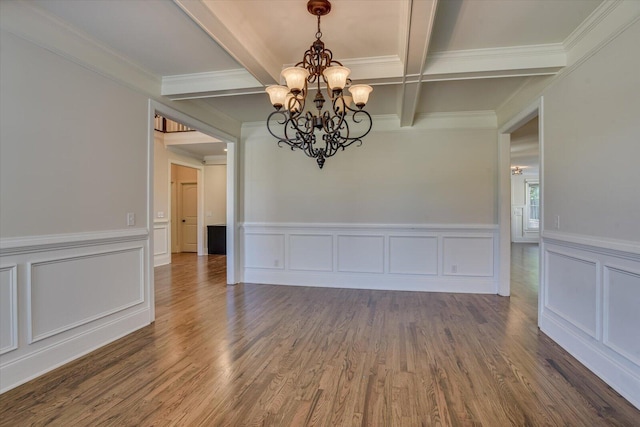 unfurnished dining area with dark wood-type flooring, coffered ceiling, crown molding, a notable chandelier, and beam ceiling