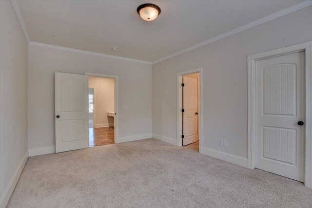 unfurnished bedroom featuring crown molding and light carpet