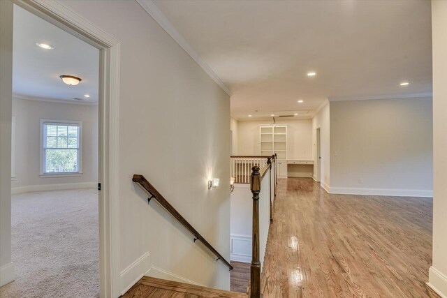 staircase with carpet floors and ornamental molding