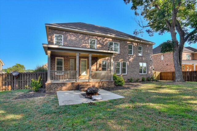 back of house featuring a fire pit, a patio area, and a lawn