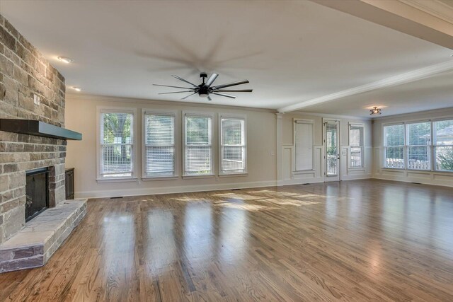 unfurnished living room with a fireplace, ceiling fan, and crown molding