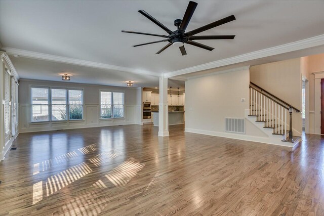 unfurnished living room featuring hardwood / wood-style flooring, ceiling fan, and ornamental molding