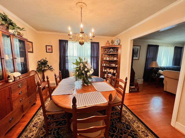 dining room with an inviting chandelier, wood finished floors, and ornamental molding