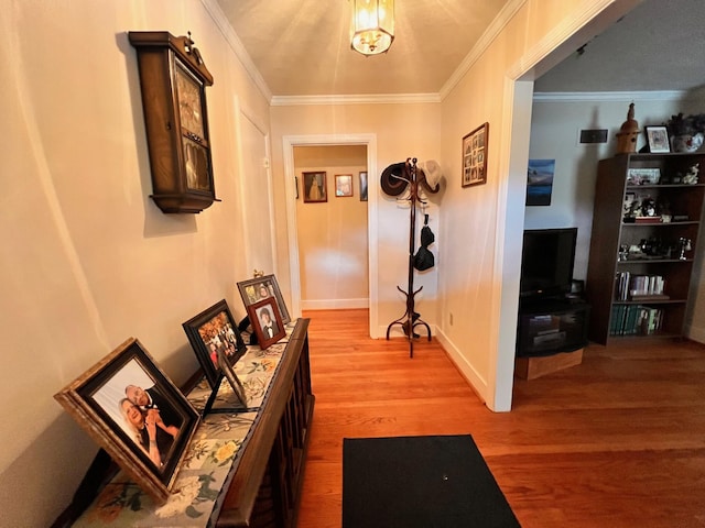 hall with baseboards, wood finished floors, and crown molding