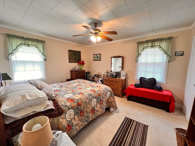 carpeted bedroom with ceiling fan and ornamental molding