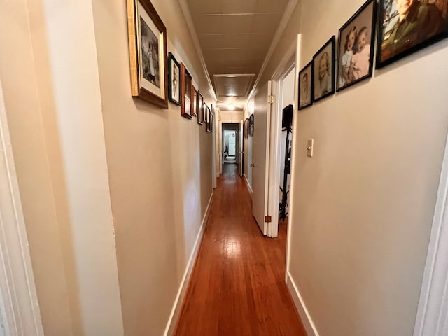 corridor featuring baseboards and wood finished floors