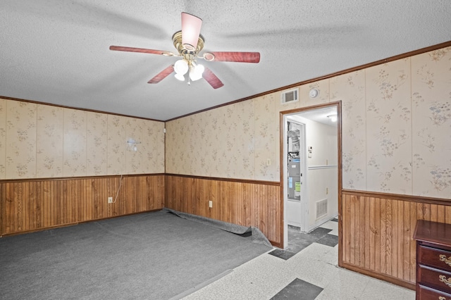 3626 Langdon Dr, Augusta, GA 30906 - empty room featuring wainscoting, ceiling fan, a textured ceiling, ornamental molding, and wood walls