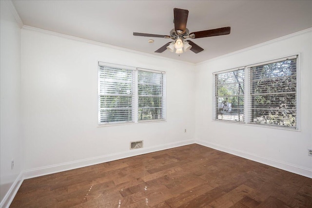 spare room featuring dark wood-style flooring, visible vents, crown molding, and baseboards