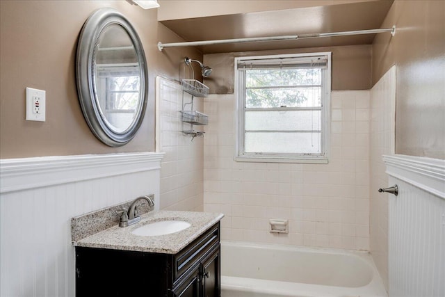 bathroom featuring  shower combination, a wainscoted wall, and vanity