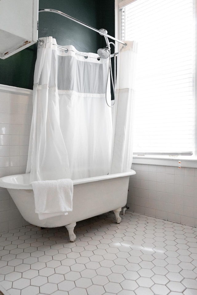 bathroom featuring tile walls and a washtub