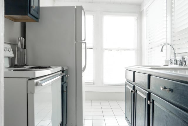 kitchen with light tile patterned floors, plenty of natural light, sink, and white electric range oven