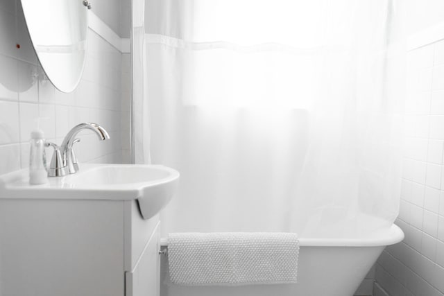 bathroom featuring vanity and tile walls