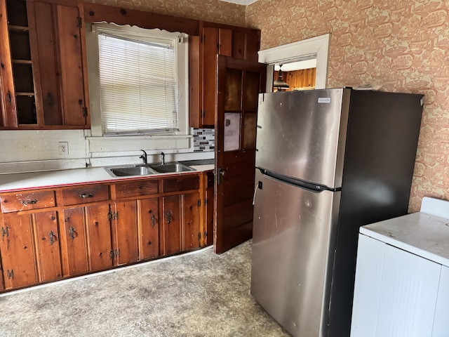 912 Holden St, Augusta, GA 30904 - kitchen with wallpapered walls, freestanding refrigerator, a sink, decorative backsplash, and light countertops