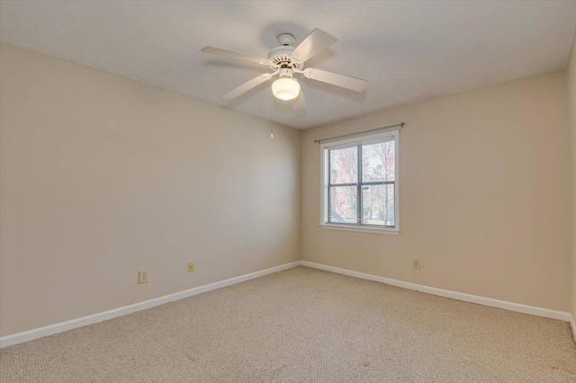 unfurnished room with carpet flooring, a ceiling fan, and baseboards